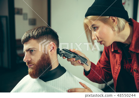 Client during beard shaving in barber shop Client during beard shaving in barber shop 48550244