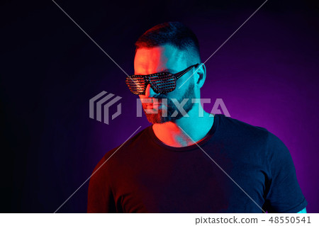 Portrait of a bearded serious man at studio. High Fashion male model in colorful bright neon lights 48550541