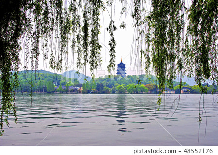 View the Yufeng Pagoda that drops shade to the lake surface from among the branches of willows hanging down to Hangzhou West Lake View the Yufeng Pagoda that drops shade to the lake surface from among the branches of willows hanging down to Hangzhou West Lake 48552176
