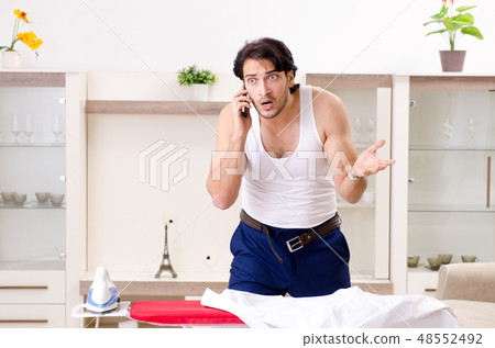 Young man ironing in the bedroom 48552492