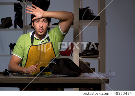 Young shoemaker in workshop at night  48553454