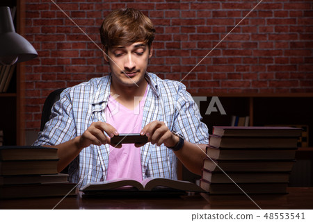Young handsome student preparing for exams at night Young handsome student preparing for exams at night 48553541