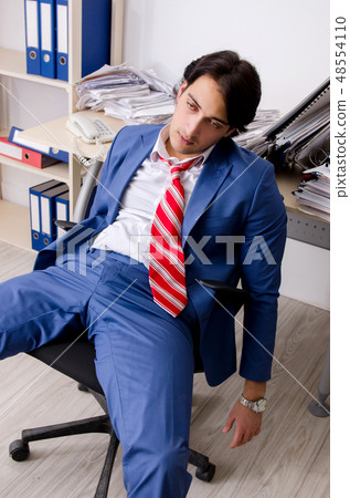 Young businessman employee unhappy with excessive work  48554110