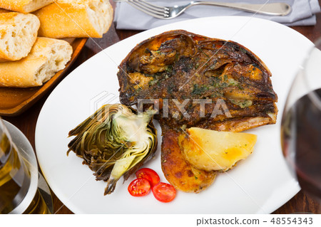 Spanish dish - lamb head with artichoke, tomatoes and potatoes 48554343