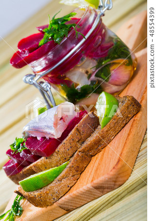 Marinated poutassou served at bread with beets, onions and marinade from lime juice 48554399