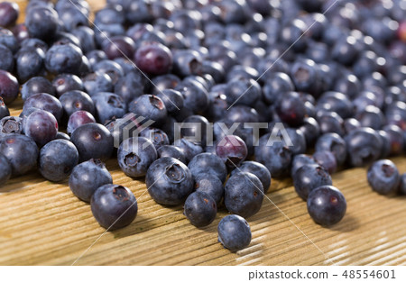 Fresh delicious blueberries on wooden table Fresh delicious blueberries on wooden table 48554601
