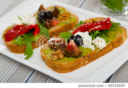 Toasts with guacamole, fresh vegetables, feta cheese Toasts with guacamole, fresh vegetables, feta cheese 48554894