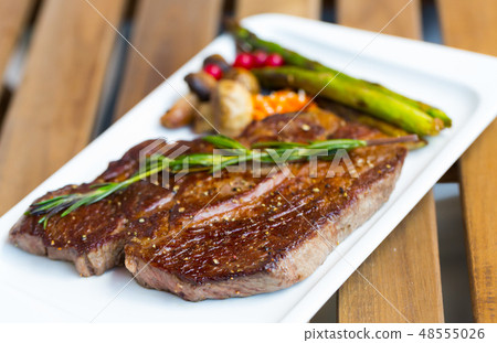 Roasted veal steak on wooden background Roasted veal steak on wooden background 48555026