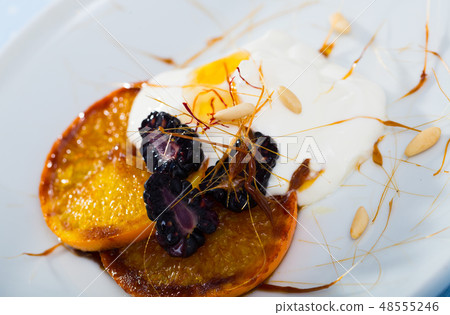 Dessert made from caramelized oranges, blackberries and yogurt 48555246