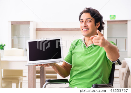 Young handsome man in wheelchair at home  48555767