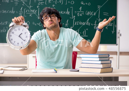 Young male student mathematician in front of chalkboard  48556875
