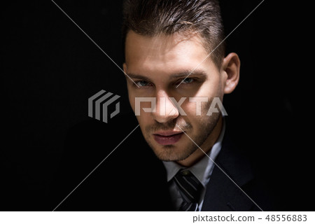 Tricky sly man face in dark room Tricky sly man face in dark room 48556883