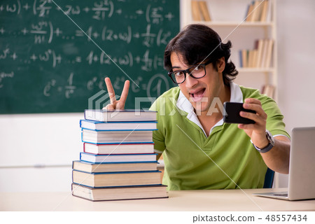 Handsome student in front of chalkboard with formulas Handsome student in front of chalkboard with formulas 48557434
