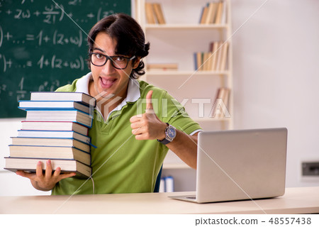 Handsome student in front of chalkboard with formulas Handsome student in front of chalkboard with formulas 48557438