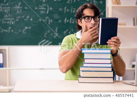 Handsome student in front of chalkboard with formulas Handsome student in front of chalkboard with formulas 48557441