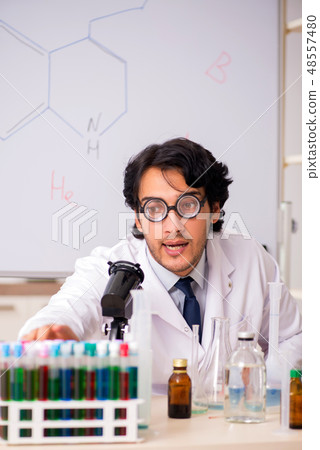 Young funny chemist in front of white board Young funny chemist in front of white board 48557480