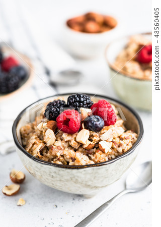 Oatmeal porridge with berries, seeds and nuts Oatmeal porridge with berries, seeds and nuts 48560405