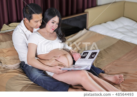 happy pregnant woman and her husband looking ultrasound scan pho happy pregnant woman and her husband looking ultrasound scan pho 48564493