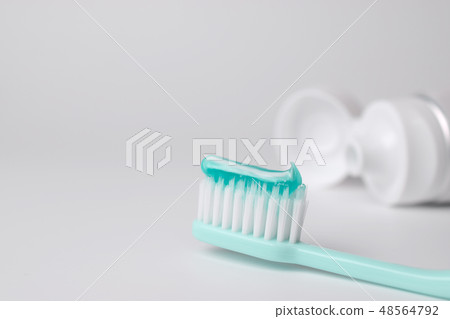 Toothbrush and toothpaste on blurred background 48564792