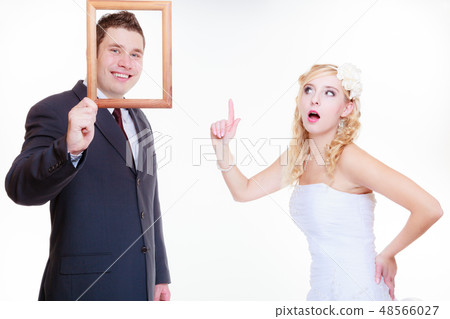 Angry groom and bride holding empty frame Angry groom and bride holding empty frame 48566027