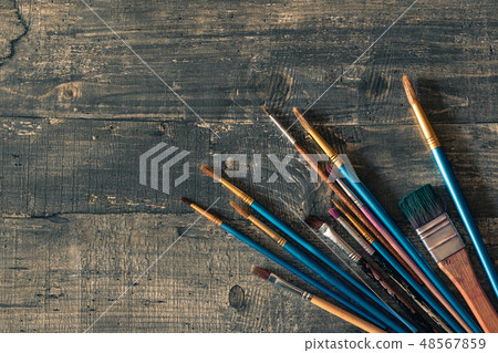 Different brushes on dark wooden desk Different brushes on dark wooden desk 48567859