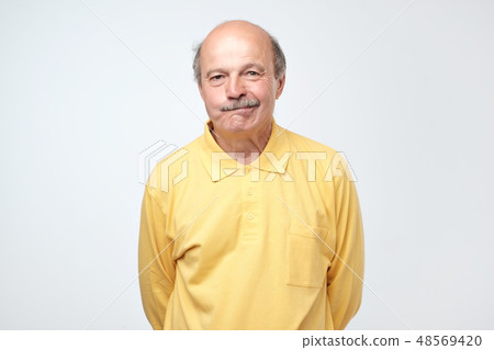 Nervous doubtful man frowning biting lips   48569420
