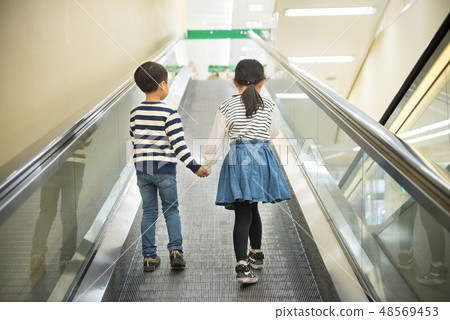 A child riding an escalator A child riding an escalator 48569453