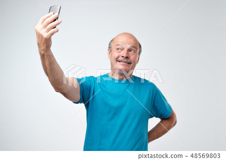 Excited senior man using mobile phone make selfie. Excited senior man using mobile phone make selfie. 48569803