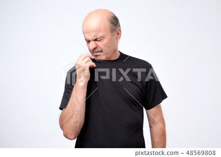 man smelling something unpleasant and bad man smelling something unpleasant and bad 48569808