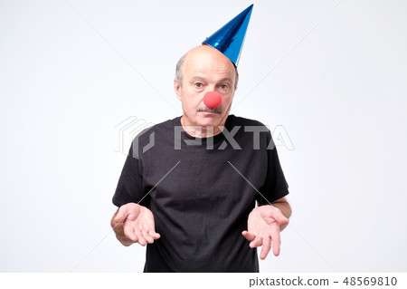 Mature businessman wearing clown nose Mature businessman wearing clown nose 48569810