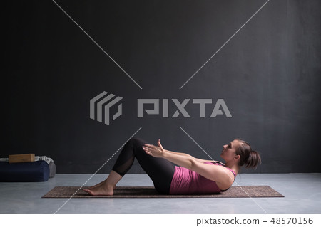 Young woman practicing yoga asana Ardha Navasana Young woman practicing yoga asana Ardha Navasana 48570156