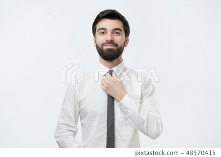 Man in shirt dressing up and adjusting tie on neck Man in shirt dressing up and adjusting tie on neck 48570415