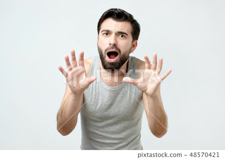 Young man is afraid and terrified with fear Young man is afraid and terrified with fear 48570421