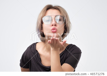 Beautiful woman sending an air kiss Beautiful woman sending an air kiss 48571276