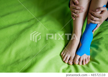 Elastic therapeutic  tape applied to patient leg. 48572110
