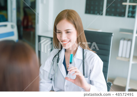 Young asian doctor showing hand press syringe Young asian doctor showing hand press syringe 48572491