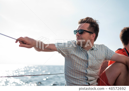 sailor relaxing happily on sailboat yacht. sailor relaxing happily on sailboat yacht. 48572692