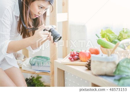 woman using camera Taking pictures to vegetables woman using camera Taking pictures to vegetables 48573153