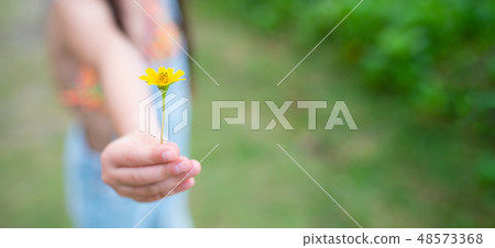 Girls offering yellow flowers Girls offering yellow flowers 48573368