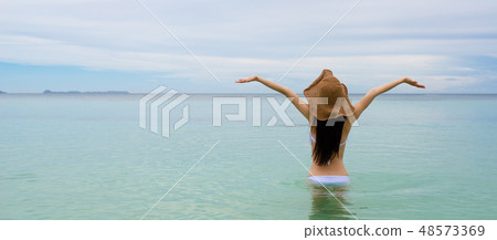 A woman relaxing by the sea A woman relaxing by the sea 48573369