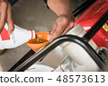 Farmer fill oil into water pump engine 48573613