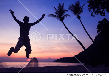 Asian man jumping fun on the beach at sunrise 48575793