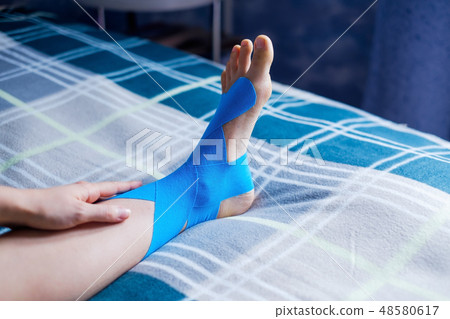 Elastic therapeutic tape applied to patient leg. 48580617