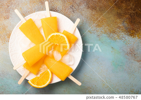 Orange popsicles with juice. 48580767