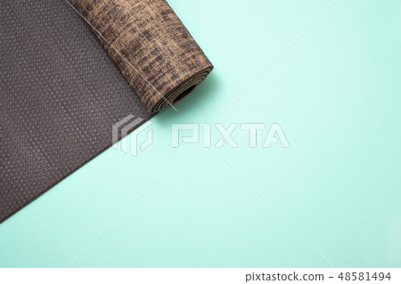 New yoga mat on a colored blue background. New yoga mat on a colored blue background. 48581494