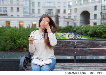 Closeup portrait of female with eyeglasses in hand. 48581996