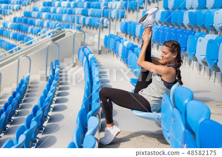 young girl sitting on the seat in the stadium. young girl sitting on the seat in the stadium. 48582175