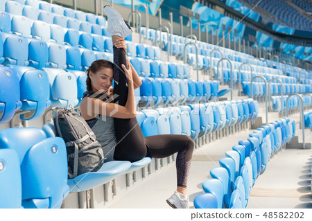 young girl sitting on the seat in the stadium. 48582202