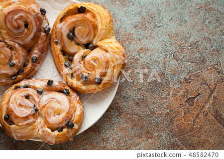 Fresh buns with raisins and icing. 48582470