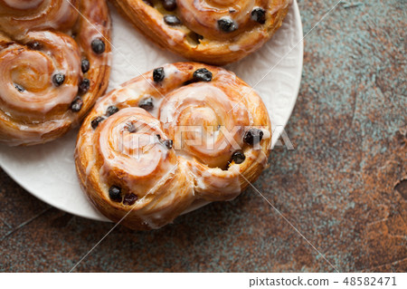 Fresh buns with raisins and icing. 48582471
